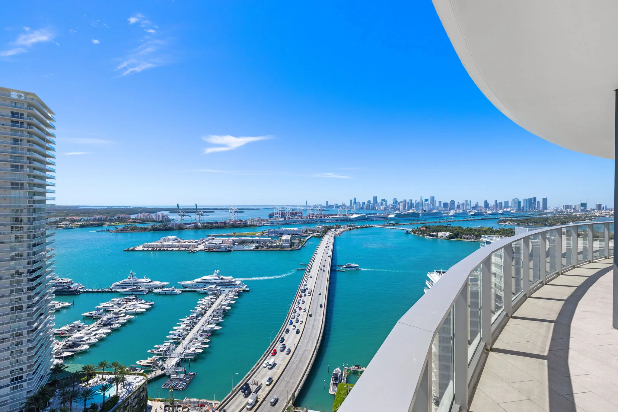 Balcony view overlooking the MacArthur Causeway, Fisher Island, Port of Miami, and the stunning Miami skyline.