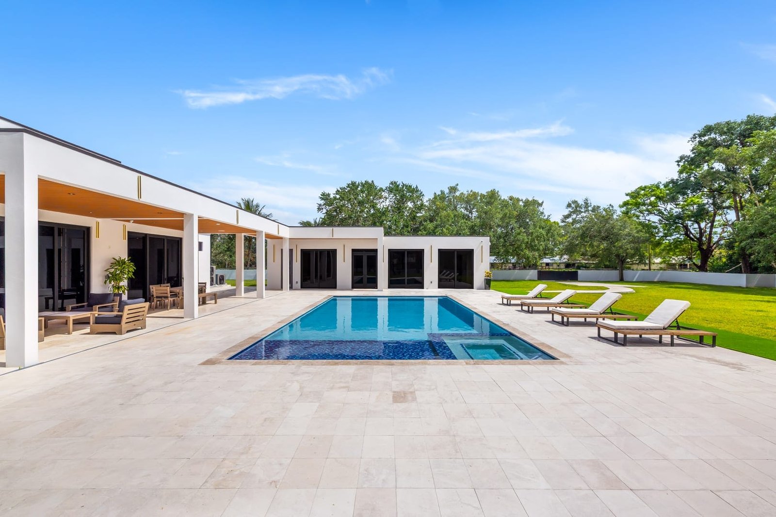 Daytime pool and backyard view at a Cooper City luxury estate